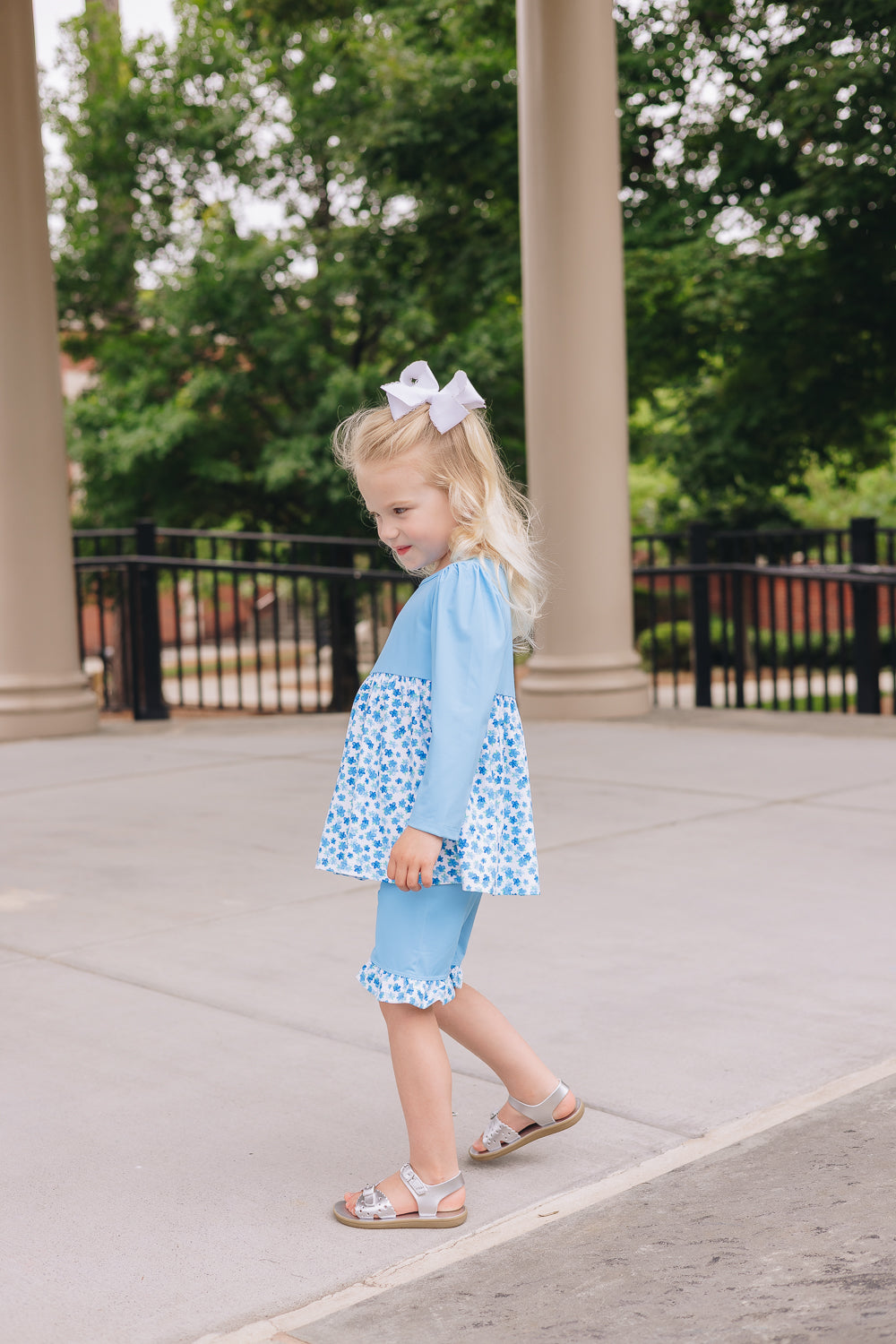 little girl wearing blue blossoms UPF 50+ top and shorts